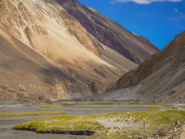 Valley landscape in Kashmir and Ladakh, India, with mountains in the distance.