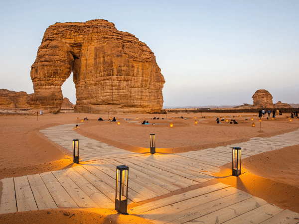 Tourists enjoying the sunset view of Elephant Rock with a wooden walkway in the foreground