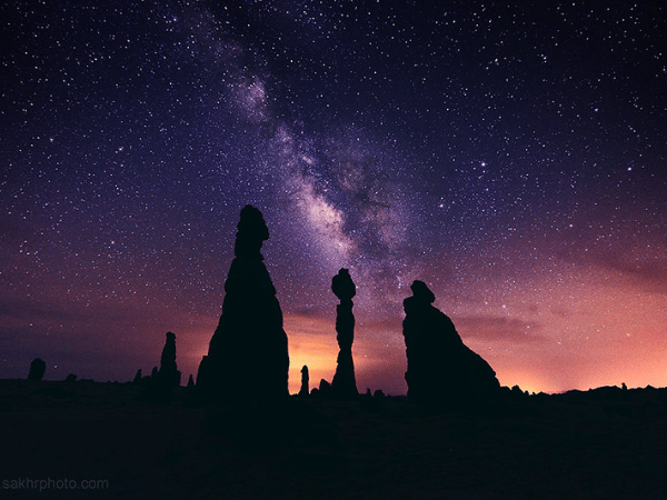 A stunning night sky view of Al Gharameel rock formations in AlUla, Saudi Arabia, with the Milky Way galaxy stretching across the horizon