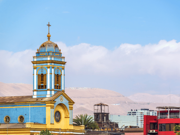 Historic blue church surrounded by sand dunes in Iquique, Chile – DMC Chile