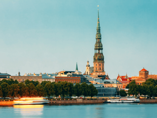 Scenic view of St. Peter’s Church and Riga’s historic skyline along the Daugava River – an ideal destination for travelers with a leading DMC in Latvia.