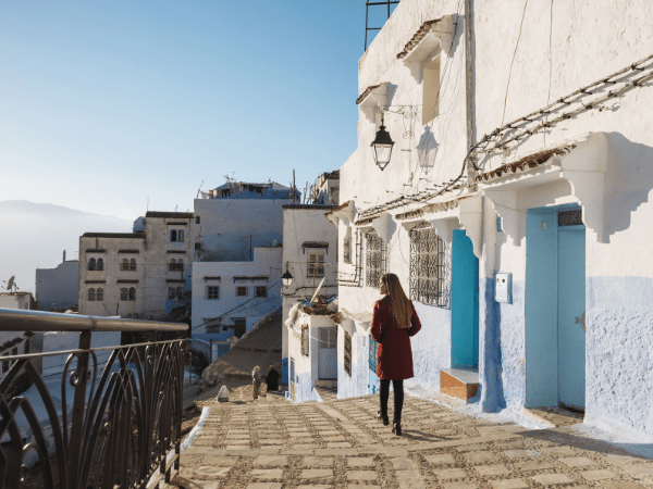 A woman exploring the blue city of Chefchaouen, showing a personalized and immersive tour experience with a DMC in Morocco.
