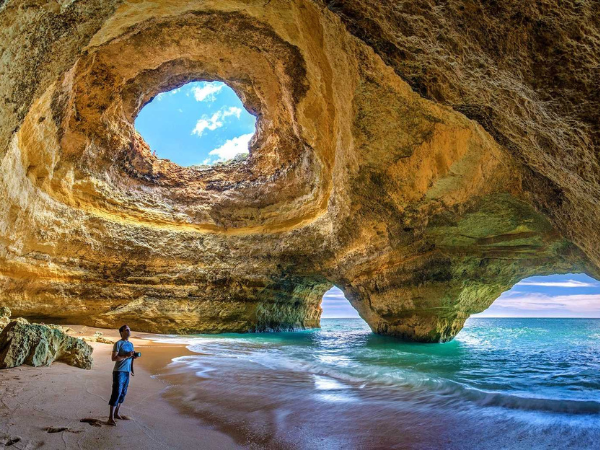 The Benagil Cave, a sea cave in the Algarve region of Portugal, with sunlight streaming through a natural opening in the rock.