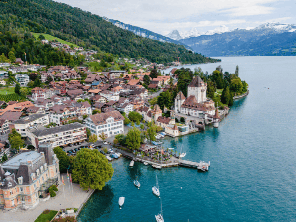 A breathtaking aerial view of Oberhofen Castle and Lake Thun, representing exclusive venues curated by a DMC in Switzerland.