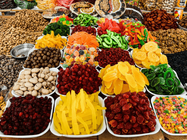 A variety of dried fruits and nuts on display at a market stall.