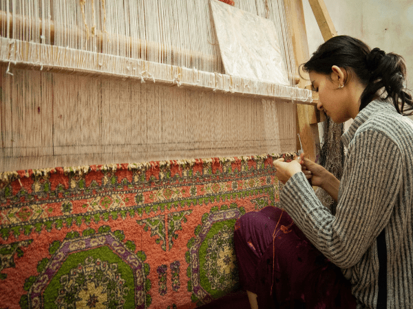 Uzbek carpet weaver at her loom.